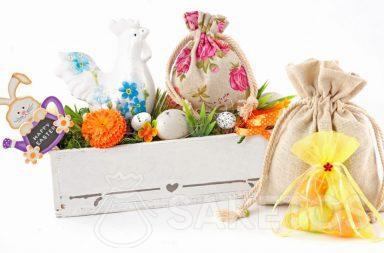 Une composition de Pâques crée avec des sachets tissu et un pot-à-fleurs rectangulaire avec des œufs colorés