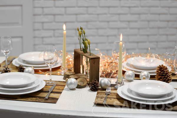Table de Noël avec une nappe blanche - nappe blanche et accessoires en bois