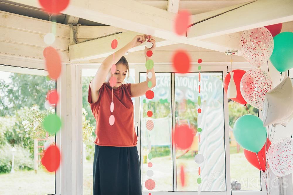 Jeune femme accrochant des décorations pour une fête