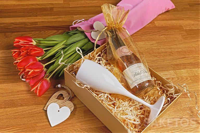 Des fleurs dans une élégante pochette en velours et un coffret cadeau avec un verre - le cadeau idéal pour la Journée de la femme