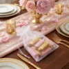 Sacs en organza remplis de friandises sur une table de mariage.