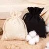 Lot de sacs en coton bio noirs et naturels avec branche de coton.