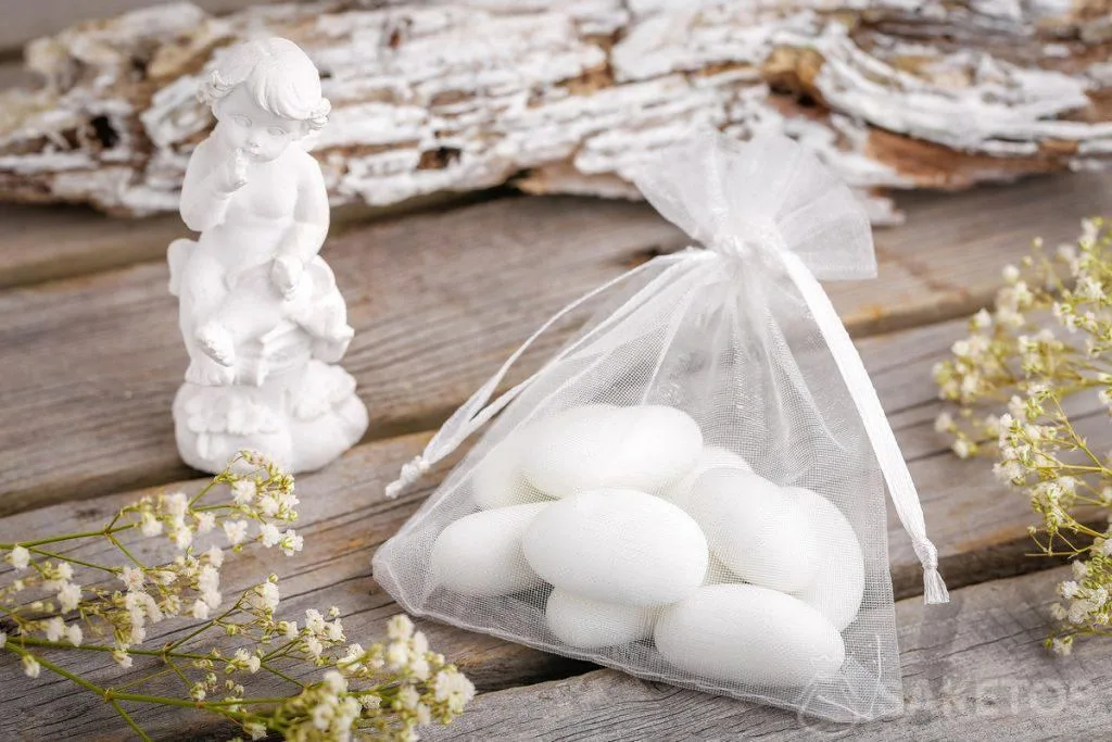Idées de cadeaux invités mariage - dragées amandes ou figurine d’ange emballés dans un sachet en organdi