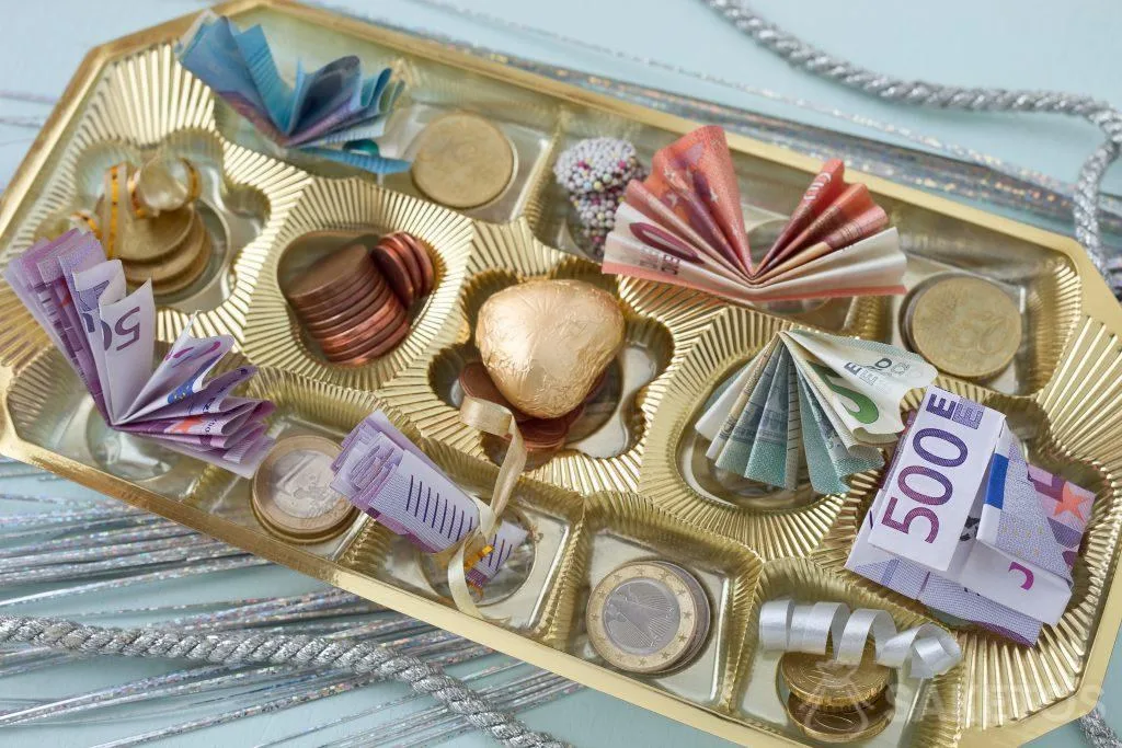 Les billets de banque et de la monnaie rangés dans une boîte de pralinés
