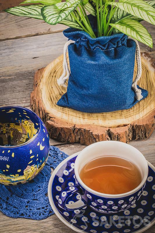 4.La tasse céramique avec du thé et le sac en jean pour un pot de fleurs