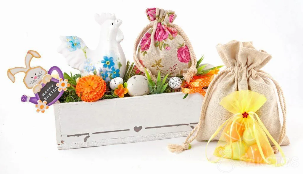 Une composition de Pâques crée avec des sachets tissu et un pot-à-fleurs rectangulaire avec des œufs colorés