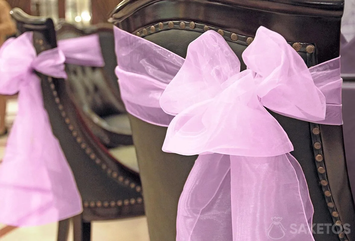 Un nœud de ruban décoratif en organdi réalisé avec le dossier de la chaise.