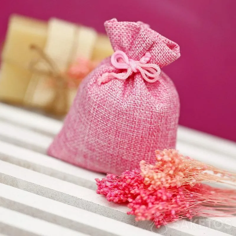Une pochette en jute rose pour empaqueter une savonnette naturelle.