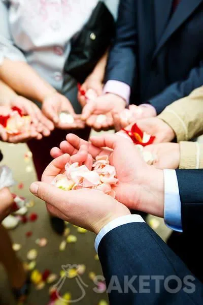 Les invités attendent de pouvoir arroser les jeunes mariés à la sortie de l'église.
