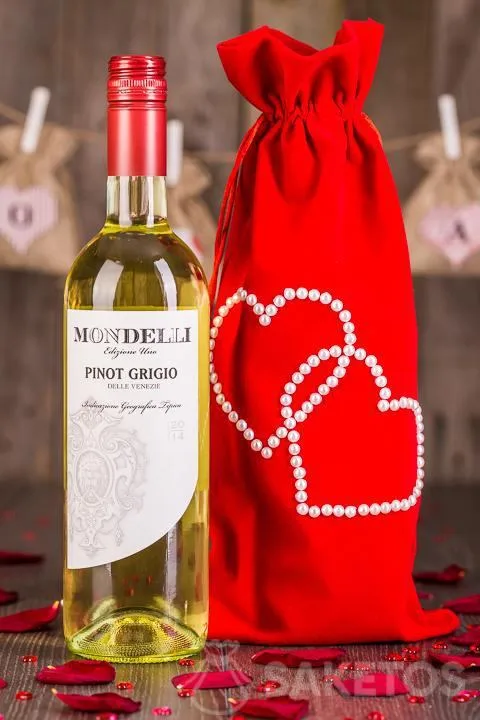 Une bouteille de vin en cadeau emballée dans un sachet décoratif en velours rouge