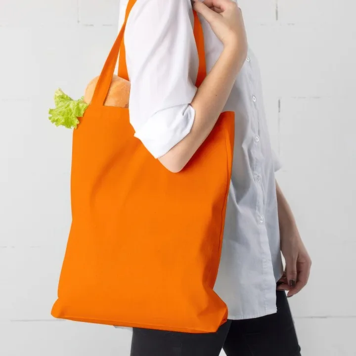 Sac de courses réutilisable en tissu orange porté à l'épaule pour les achats du quotidien