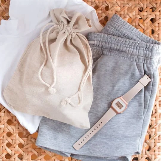 Sac à vêtements en tissu avec vêtements pliés et montre